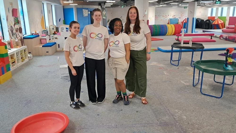 The Neurodiversity Ireland team together in the sensory centre, wearing rainbow infinity logo t-shirts
